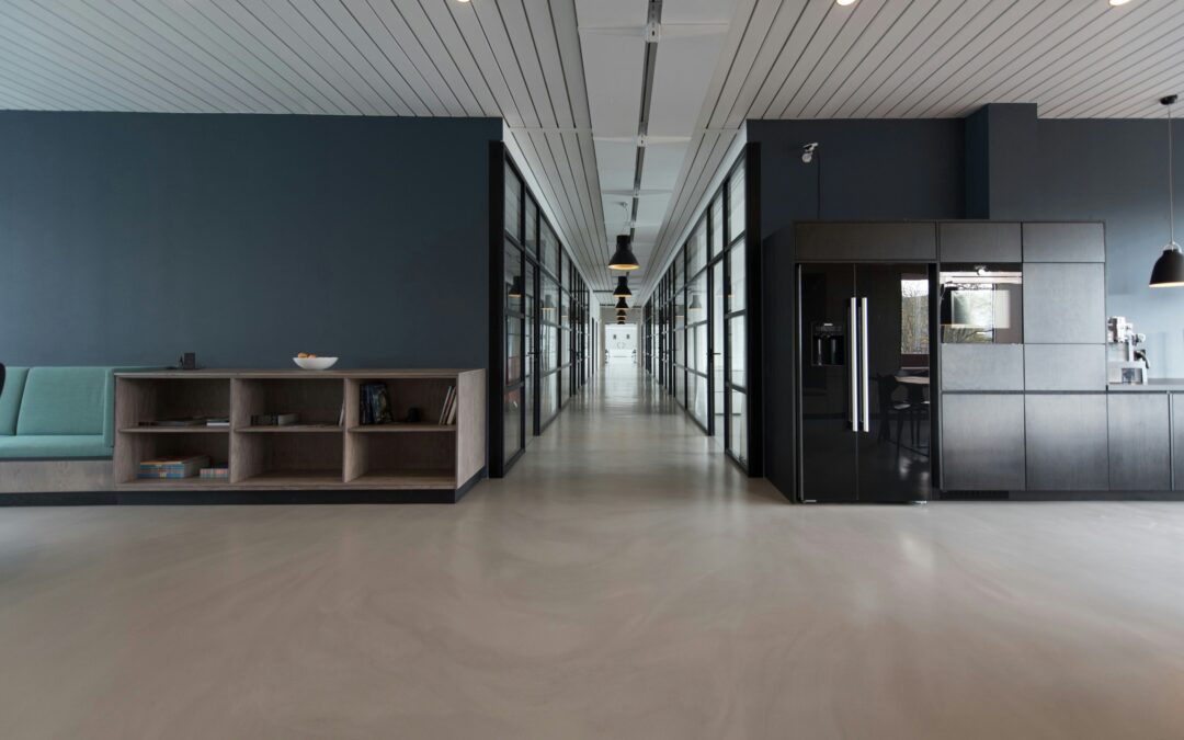 A modern building interior showcases an open space with high ceilings. The shelves are sparsely populated, emphasizing the clean lines and spaciousness of the area.